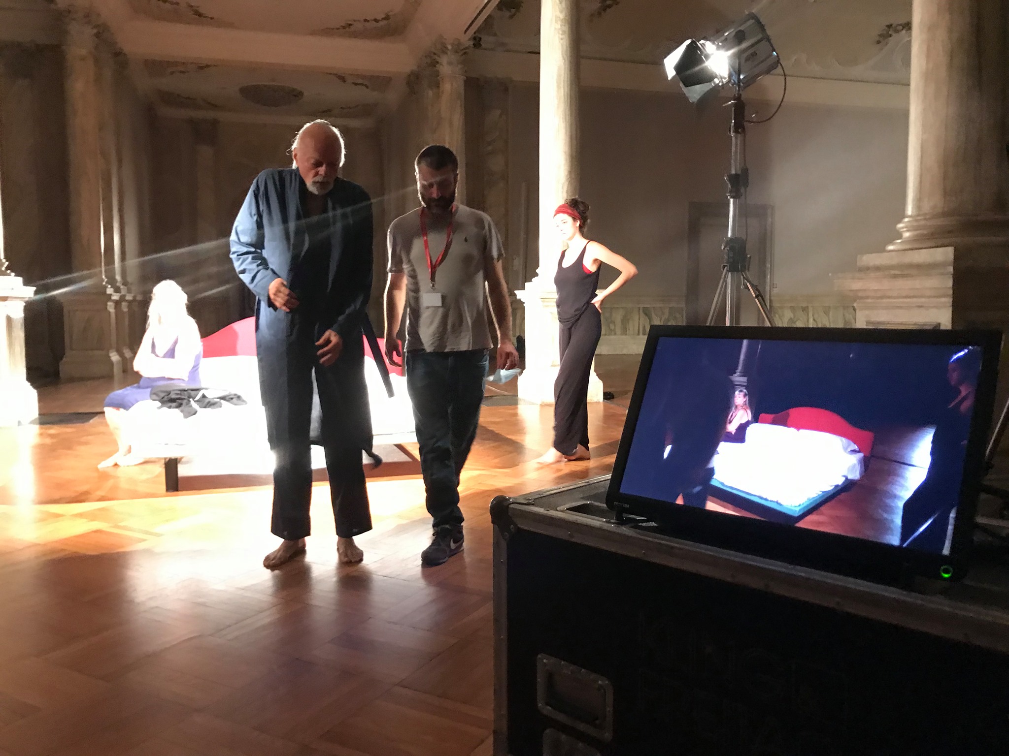 A monitor shows video of a scene while creative professionals work on set for The Right Way in the background.