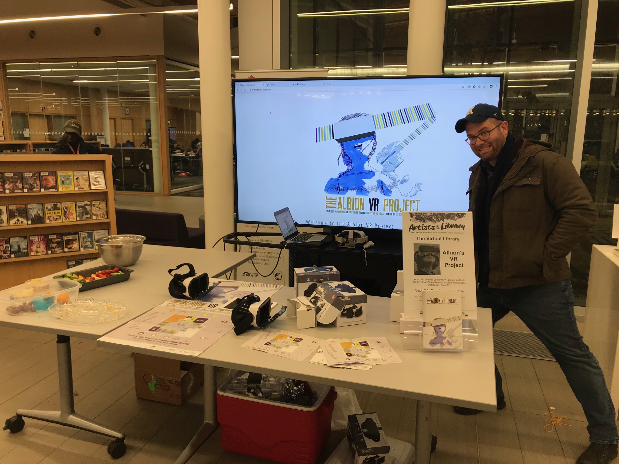 Ian Garrett smiles in front of the display of equipment and information for the VR workshop at Albion Library